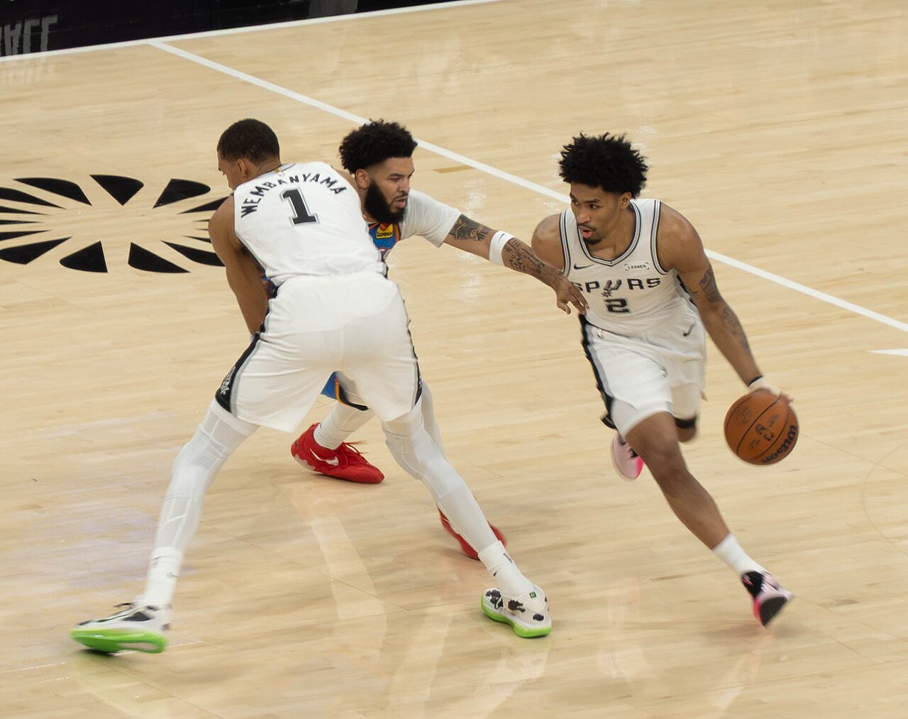 San Antonio Spurs guard Dylan Harper drives with the ball as Victor Wembanyama sets a screen on an Oklahoma City Thunder defender during the 2026 West finals